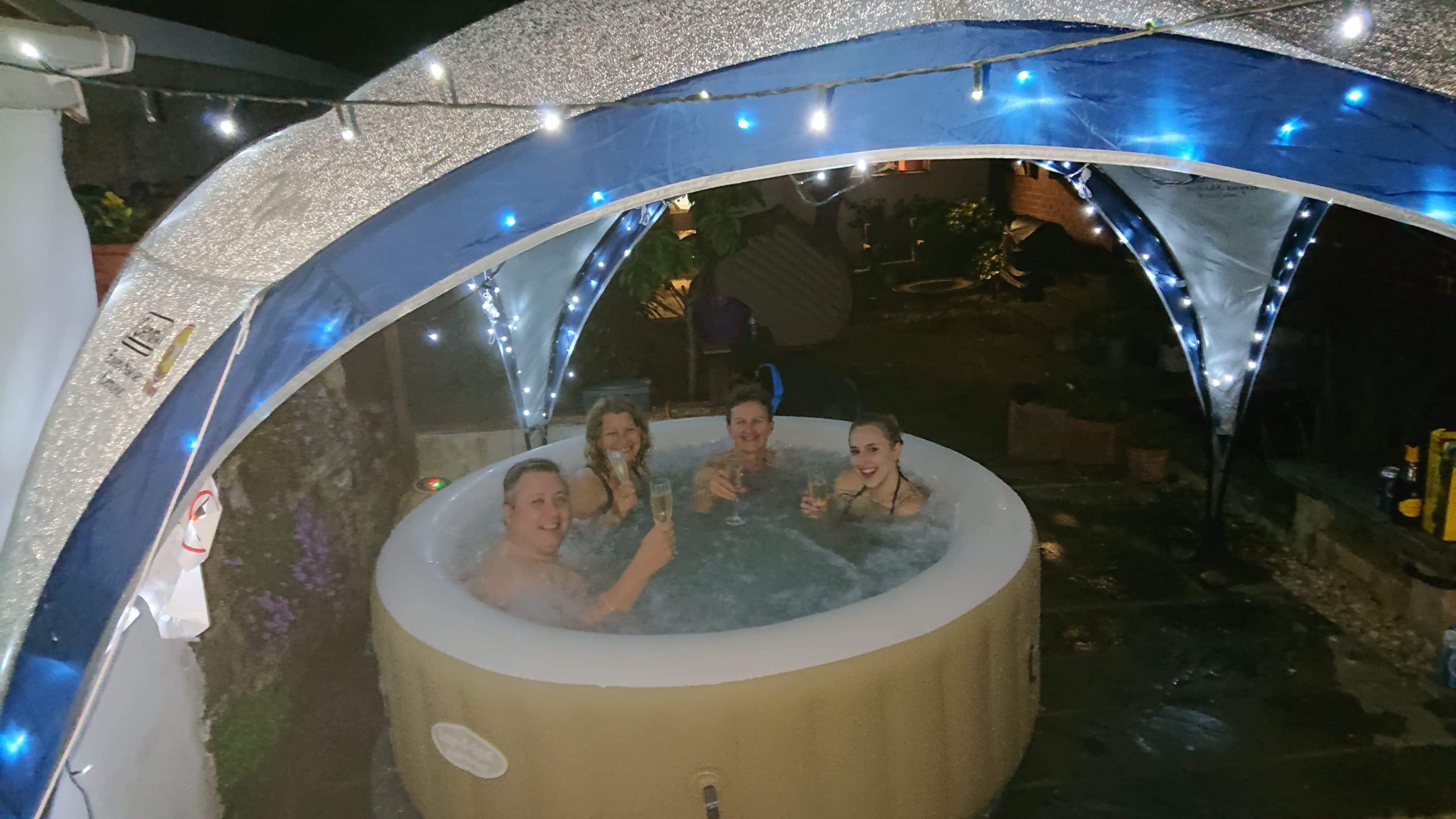 People drinking champagne in the hot tub at the Care For Kids North Devon Bubbles Party