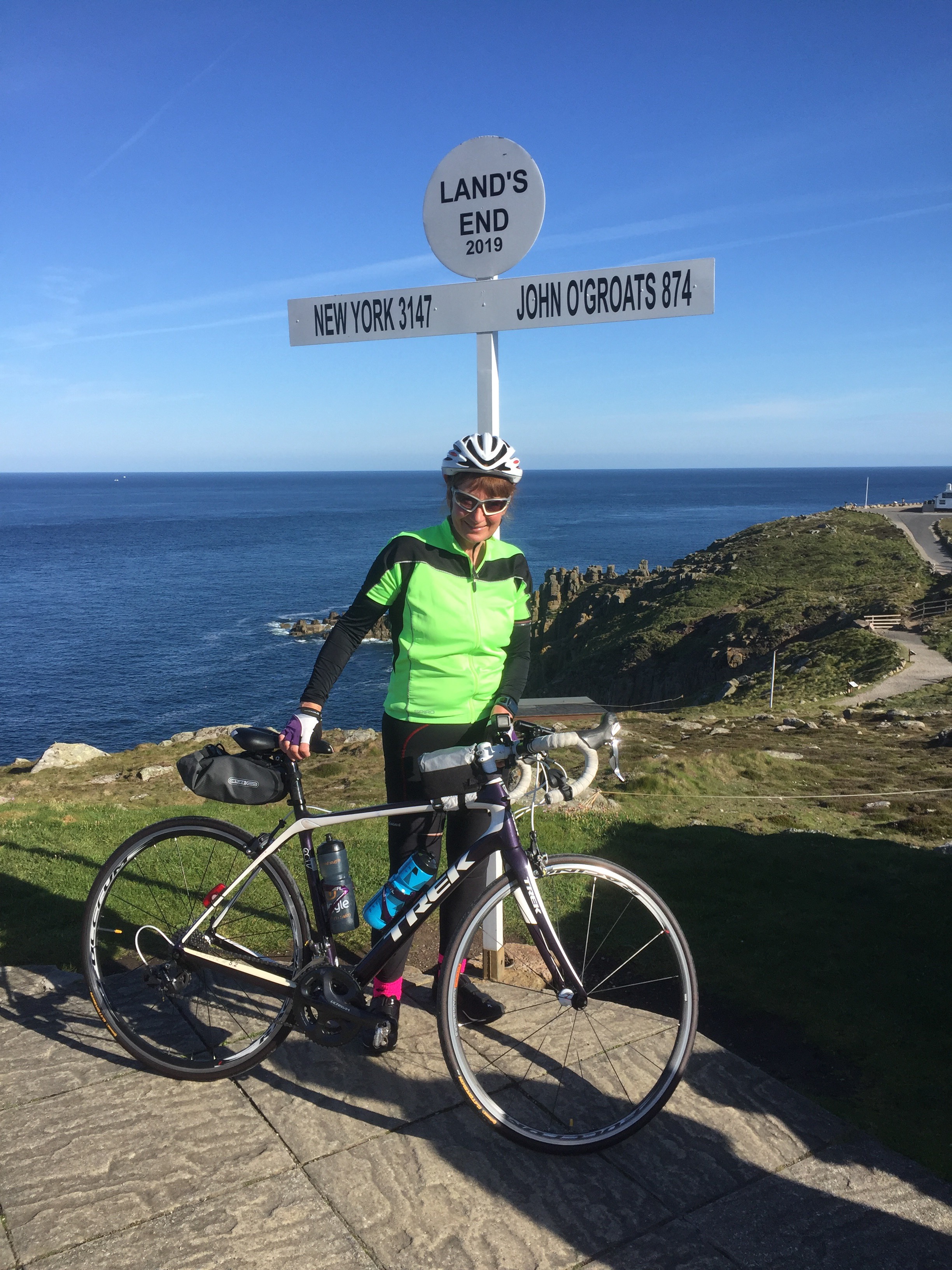 Jacky on her bike at Lands End on her way to John O'Groats